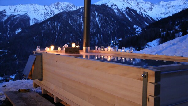 A wooden sauna with a glass enclosure, set against a snowy mountain backdrop. - La Tzoumaz, 'BeauChalet'. Large 8-person chalet, Ski In, ski out (La Tzoumaz)