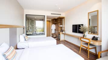 A hotel room with two beds, a desk with a chair, a TV, and a large mirror.