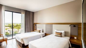 A hotel room with two beds, large windows, and a view of the city.