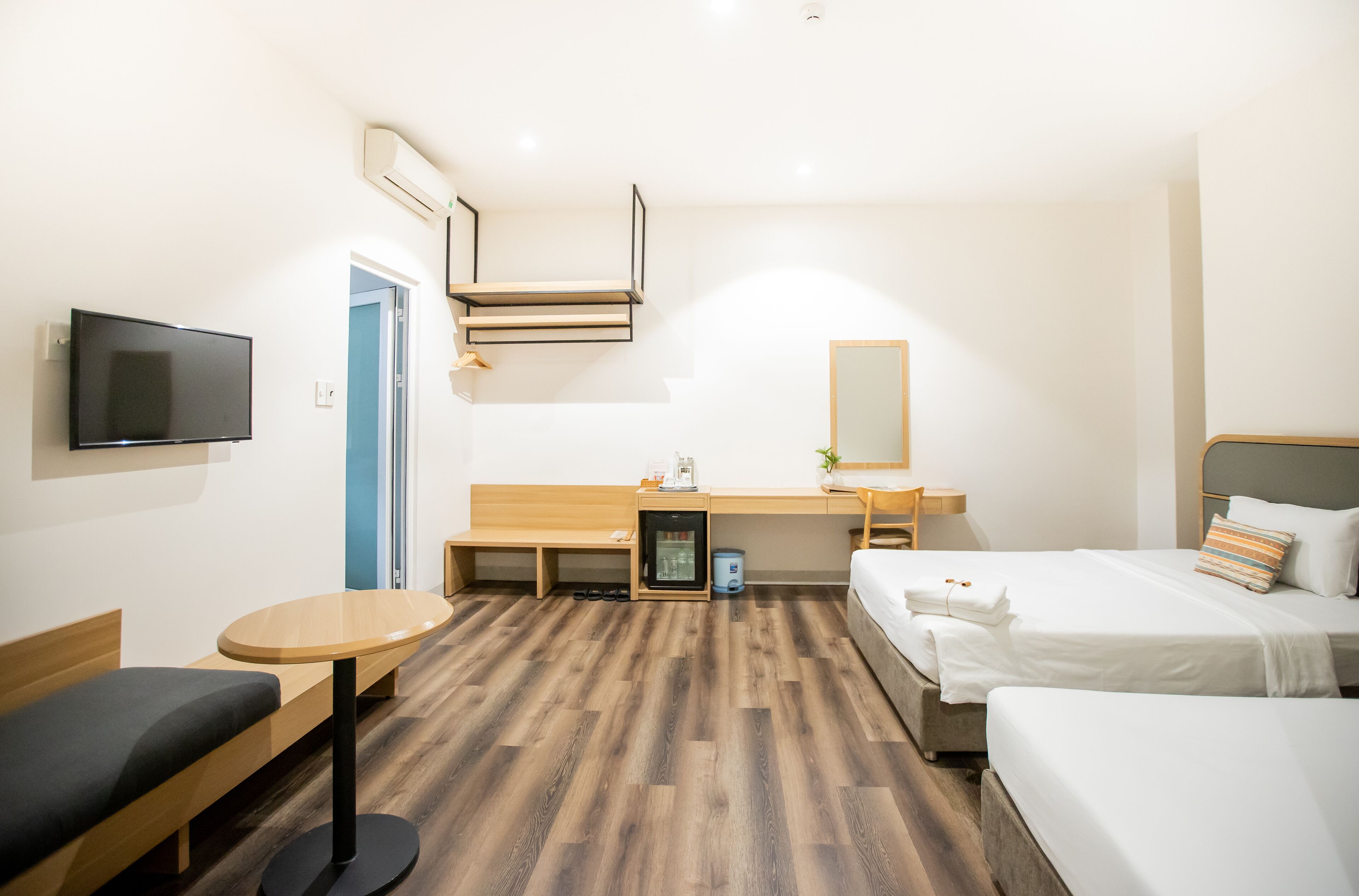 Una habitación de hotel con una cama, un escritorio, una silla, un televisor y una mesita.
