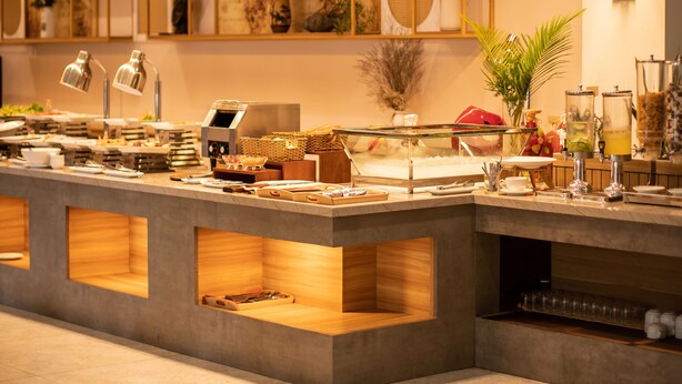 Une cuisine moderne dotée de meubles encastrés, d’un îlot central avec un évier et de divers appareils de cuisine.