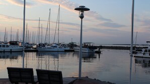 Un puerto deportivo con barcos amarrados, un farol y un banco.