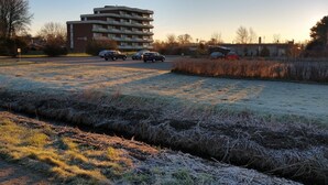 A parking lot with a multi-story building in the background. - Bungalow 58 sqm, 300 m from the beach and subtropical bathing paradise, WLAN (Niedersachsen)