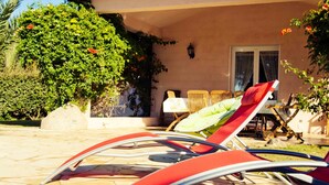 A patio with two red lounge chairs, a table, and a chair set. - Magnificent villa with sea view  (Zonza)