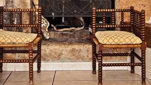 A fireplace with a unique wooden mantel, two wooden chairs with cushions, and a stone wall. - Magnificent villa with sea view  (Zonza)