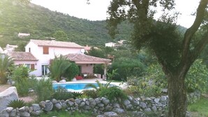 A house with a swimming pool, surrounded by a stone wall and greenery, with hills in the background. - Magnificent villa with sea view  (Zonza)