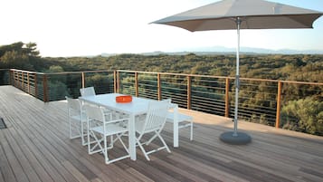 Enjoy al fresco dining on the deck with a view of the lush landscape.