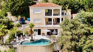 Un edificio de varios pisos con piscina, balcones y jardín.