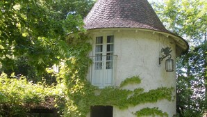 A small, white tower-like structure with a conical roof, a door, and a window.