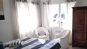 A bedroom with a bed, a chair, and a wardrobe.