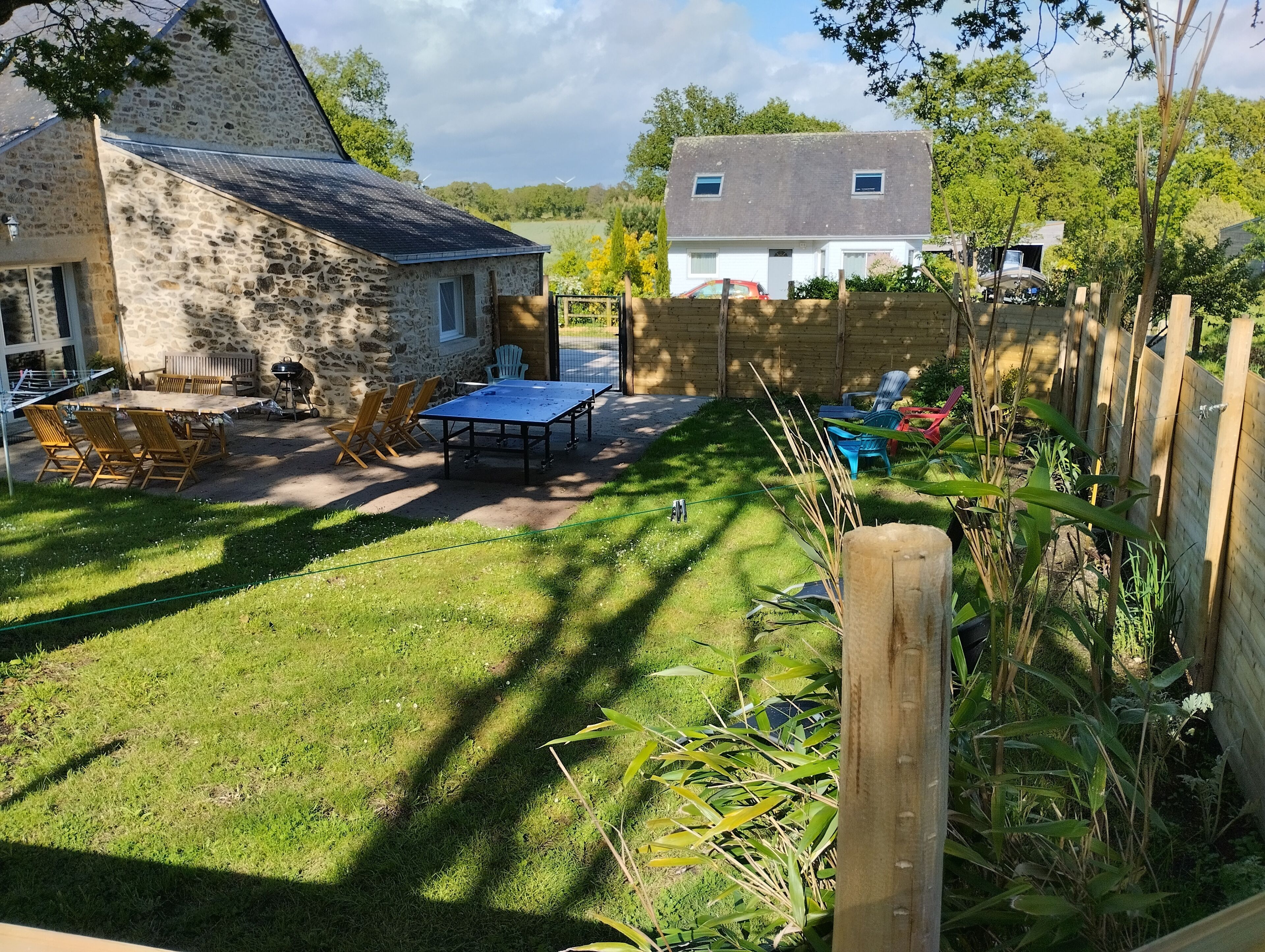 A stone house with a patio, outdoor seating, and a lawn.