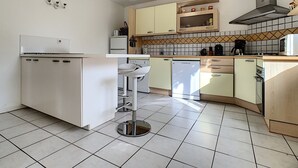 Eine moderne Küche mit weißen Schränken, einem eingebauten Geschirrspüler, einer Spüle und einem Herd.