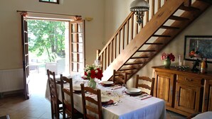 A dining area with a wooden staircase, a table set for a meal, and a view of the outdoors. - Comfortable space and well decorated (Castelsagrat)