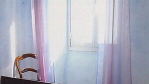 A bedroom with a wooden bed, a chair, and a window with curtains. - Apartment of 72 m2 in a house in Corsica (Olmeto)