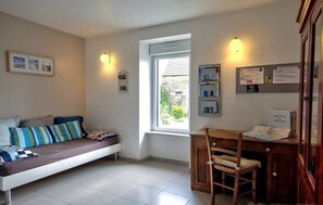 A room with a bed, a desk, and a window.