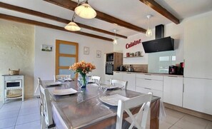A modern kitchen with white cabinets, a built-in oven, and a coffee machine.