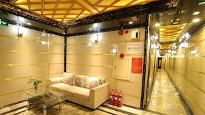 A lobby with a glass coffee table, a sofa, and a fire extinguisher. - Central Phu Hung Hotel (Quang Phu)