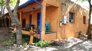 Un bâtiment rustique doté d’un porche, d’une porte bleue et d’une petite fenêtre.