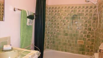 Ein Badezimmer mit einer Badewanne, einer Dusche und einem Waschbecken.