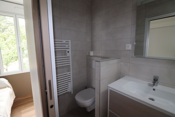 Un baño moderno con inodoro, lavabo y toallero.