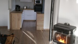 Een moderne keuken met een inbouwoven, magnetron en een houtkachel.