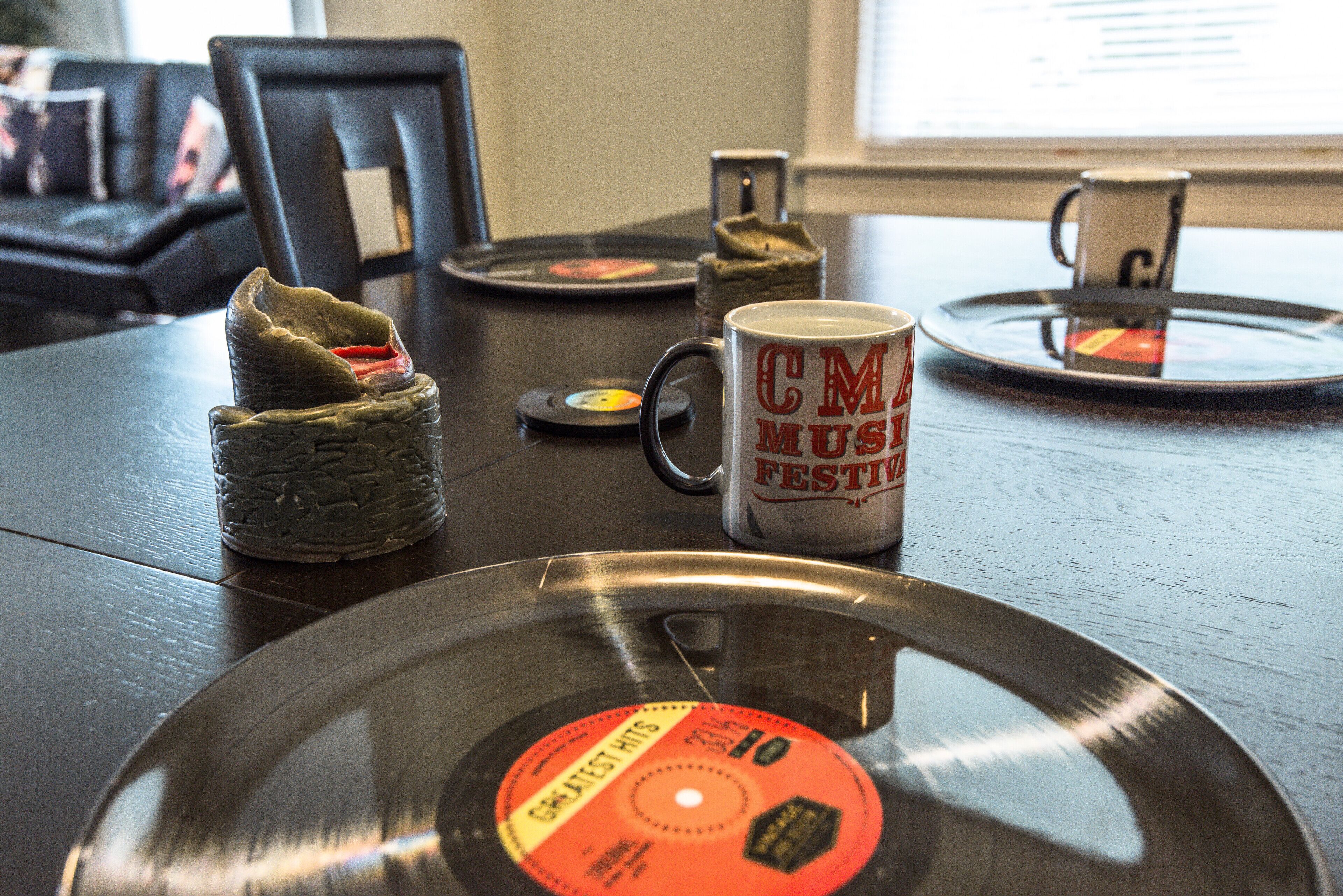 A vinyl record, a mug, and a CD player on a wooden table.