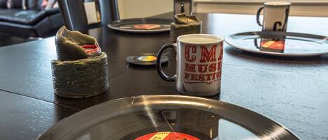 A vinyl record, a mug, and a CD player on a wooden table.