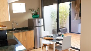 Una cocina moderna con comedor, refrigerador y ventana con vistas a un jardín.