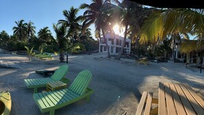 Une plage avec des kayaks, des chaises longues et un poste de surveillance pour les sauveteurs.
