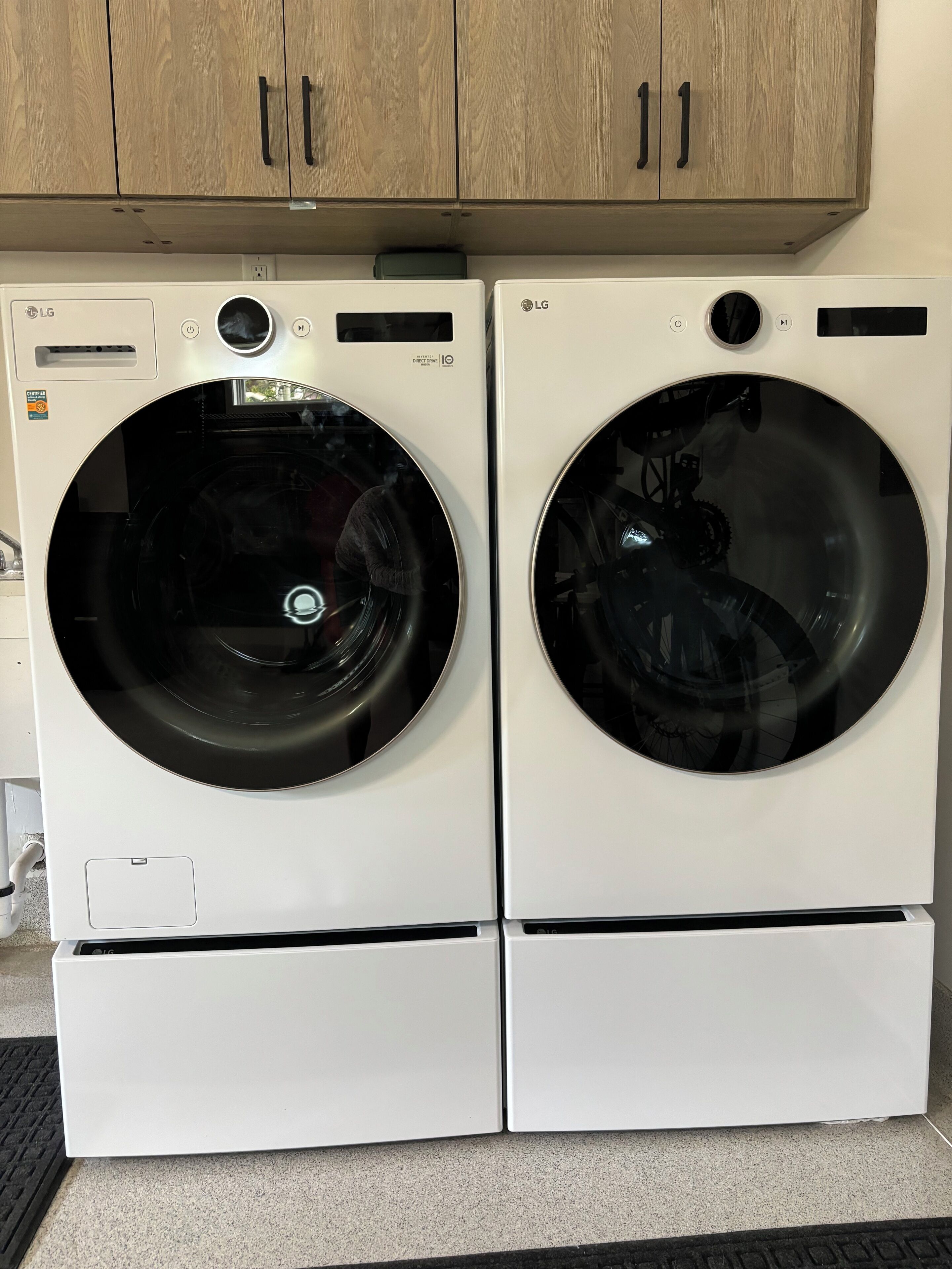 Deux lave-linge LG à chargement frontal, de couleur blanche, dotés d’un panneau de commande et d’un écran numérique.