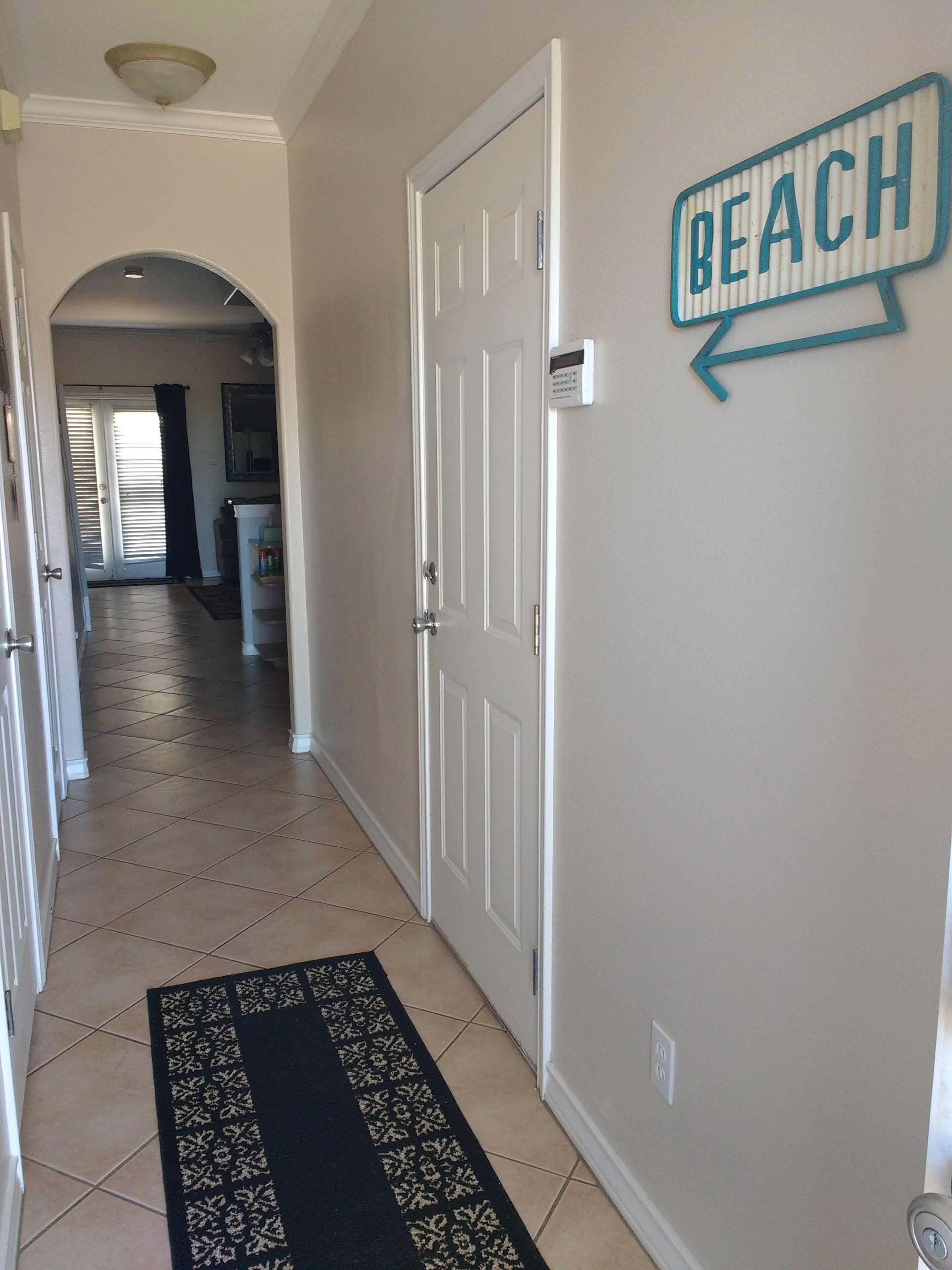 Un pasillo con un cartel que dice 'BEACH', que lleva a una puerta.