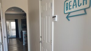Un couloir avec un panneau indiquant « PLAGE » sur le mur, qui mène à une porte.