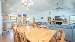A spacious living area with a wooden dining table, grey sofas, and a flat-screen TV. - 8 BEDROOMS: Book your vacation now! (Corolla)