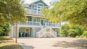 A two-story house with a balcony and a staircase leading to the upper level. - 8 BEDROOMS: Book your vacation now! (Corolla)