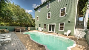 A backyard with a swimming pool, deck chairs, and a hot tub. - 8 BEDROOMS: Book your vacation now! (Corolla)