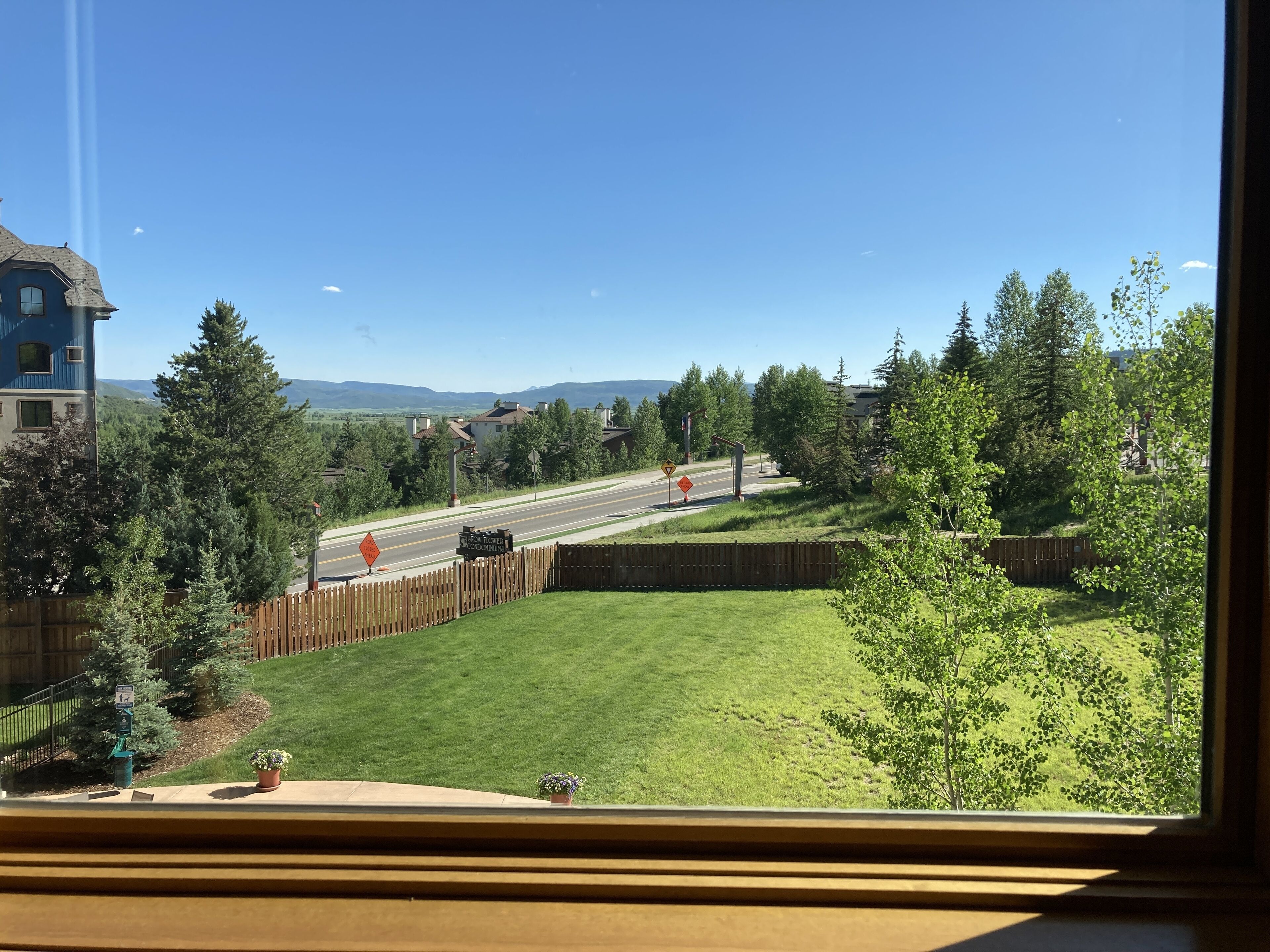 A residential area with a road, a wooden fence, and houses.