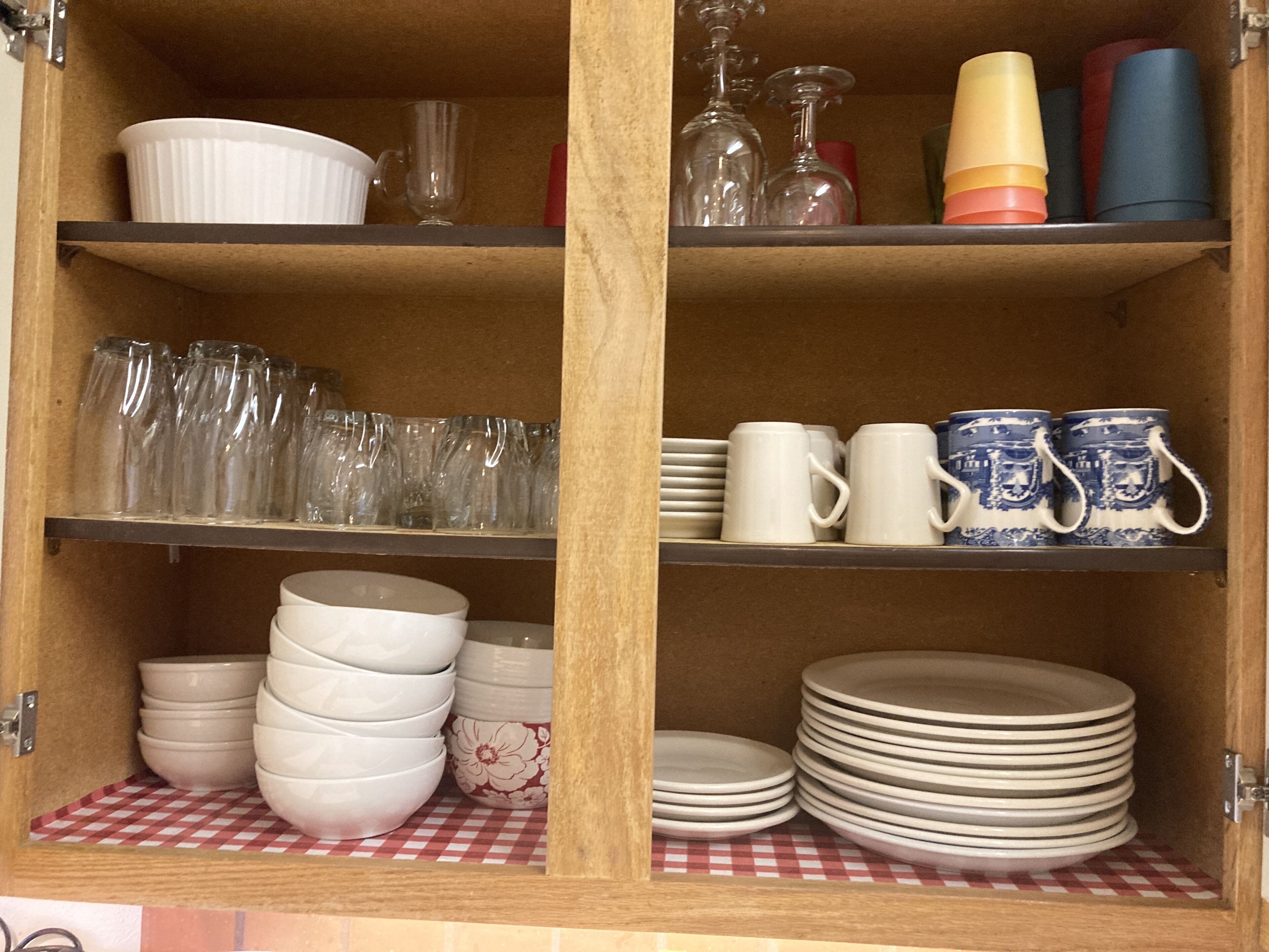A wooden cabinet with shelves holding various kitchenware items.