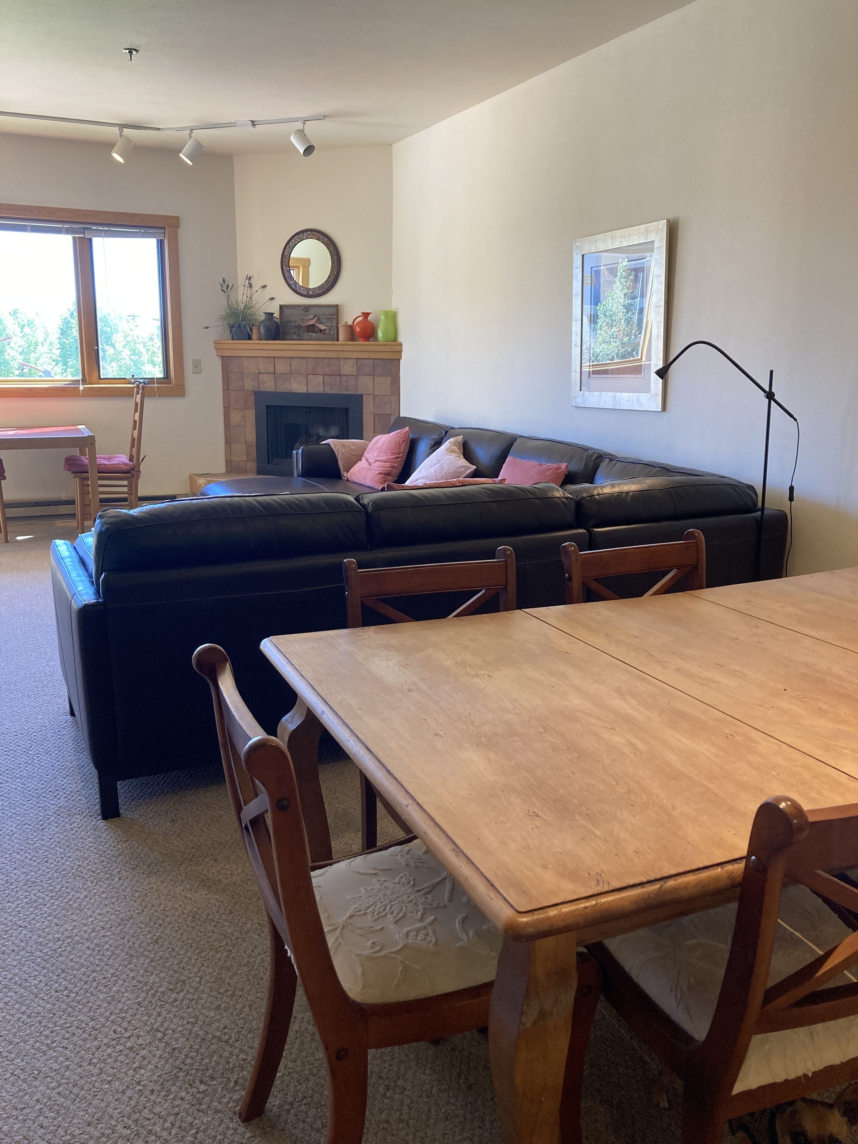 A living room with a fireplace, a sofa, a dining table, and chairs.