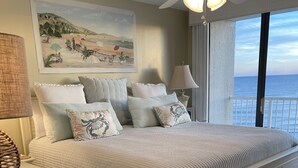 A bedroom with a bed, a ceiling fan, a painting, and a view of the sea. - EXTREME MAKEOVER- 200 5 STAR REVIEWS. DIRECT BEACH VIEWS-LUXURY AT GREAT PRICING (Orange Beach)
