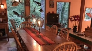 Un coin repas avec une table en bois, des chaises et un aquarium rempli de poissons.