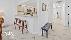 Eine moderne Küche mit Kochinsel, Barhocker und einer Bank.