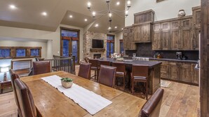 Una cocina amplia con armarios de madera, una isla grande y un comedor con mesa y sillas.