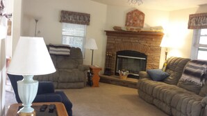 A living room with a fireplace, two sofas, a coffee table, and lamps. - WATERFRONT,PRIVATE BOAT RAMP ,SANDY BEACH GATED COMMUNITY, 3 BEDROOM & 2 BATH (Mohave Valley)