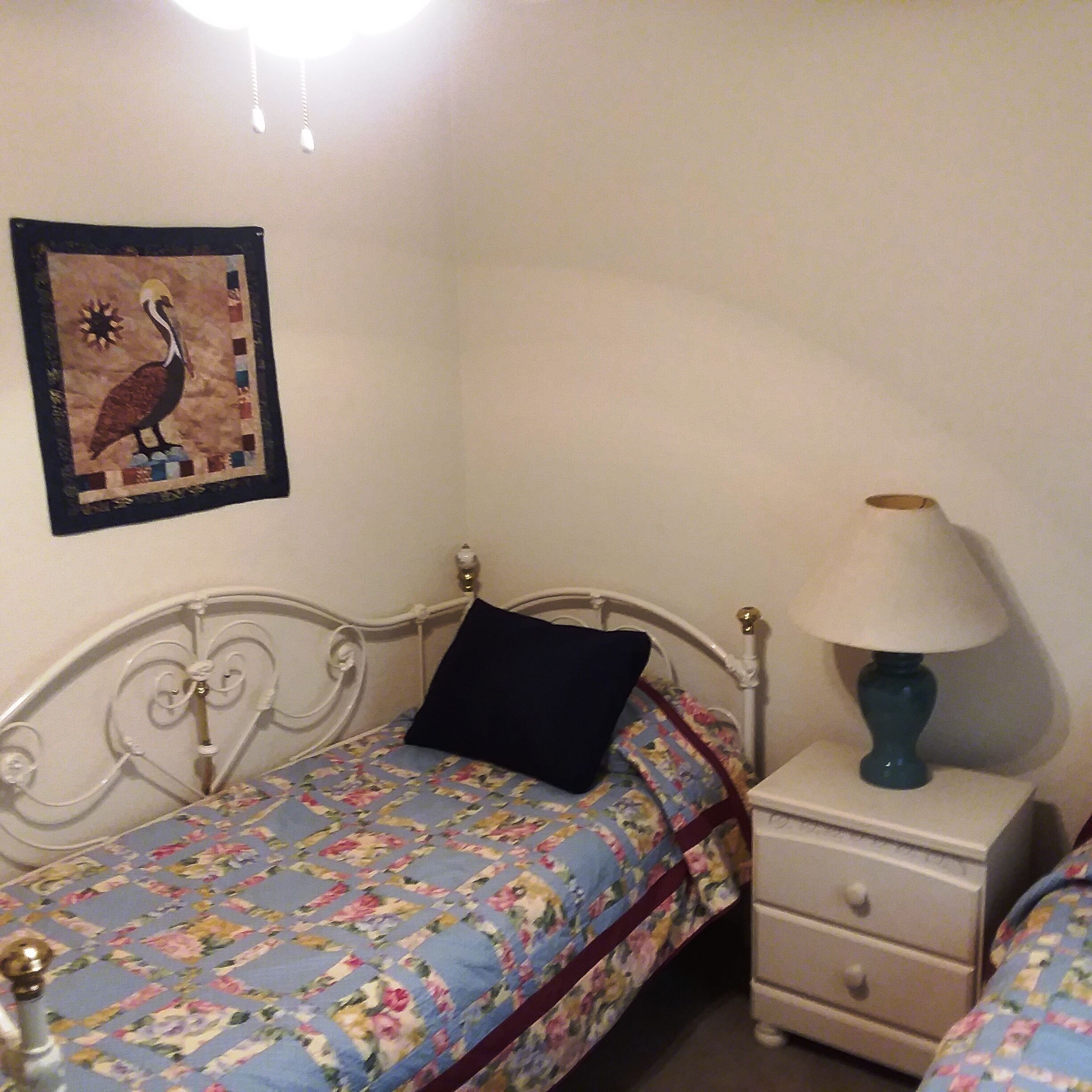 Une chambre à coucher avec un lit, une table de chevet, une lampe et un tableau ou une décoration murale.