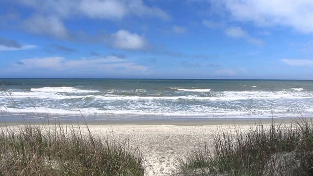 A beach with waves and clear skies. - Surfside Beach Paradise! Steps to the Beach, Ocean View, Family Friendly (Surfside Beach)