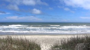 Une plage avec des vagues et un ciel dégagé.