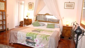 A bedroom with a canopy bed, wooden furniture, and framed pictures on the walls. - Apartment Fiore is big, romantic,  green terrace close Trastevere and Vatican (Rome)