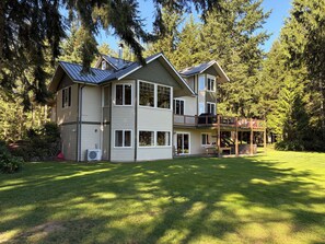 Ein zweistöckiges Haus mit einer großen Terrasse und einem überdachten Außenbereich.
