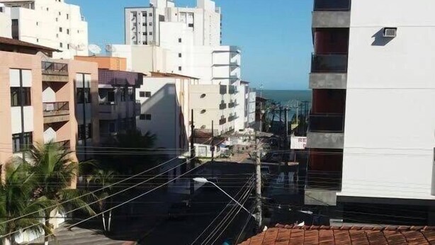 Vista de una zona residencial con edificios modernos, cielo despejado y una calle con coches estacionados.