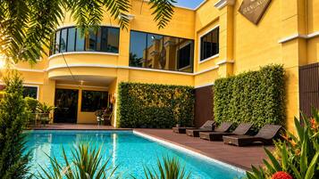 Una piscina al aire libre, sillones reclinables de piscina